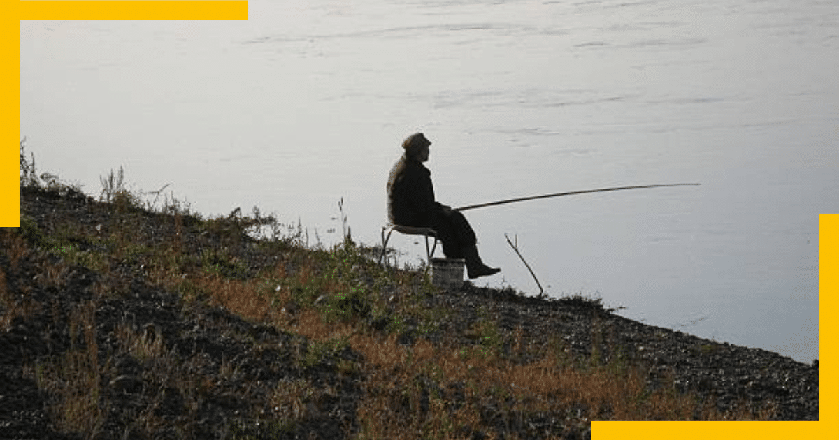 A man fishing beside a river