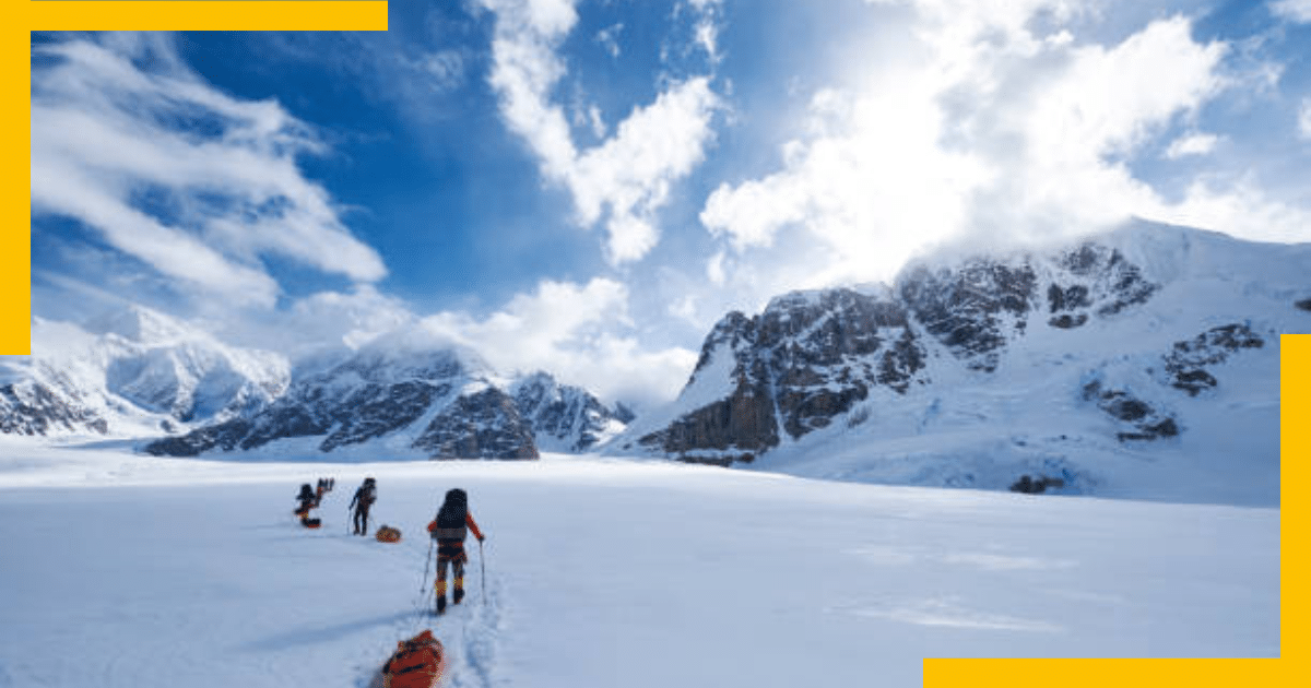 Three people hiking a snowy glacier