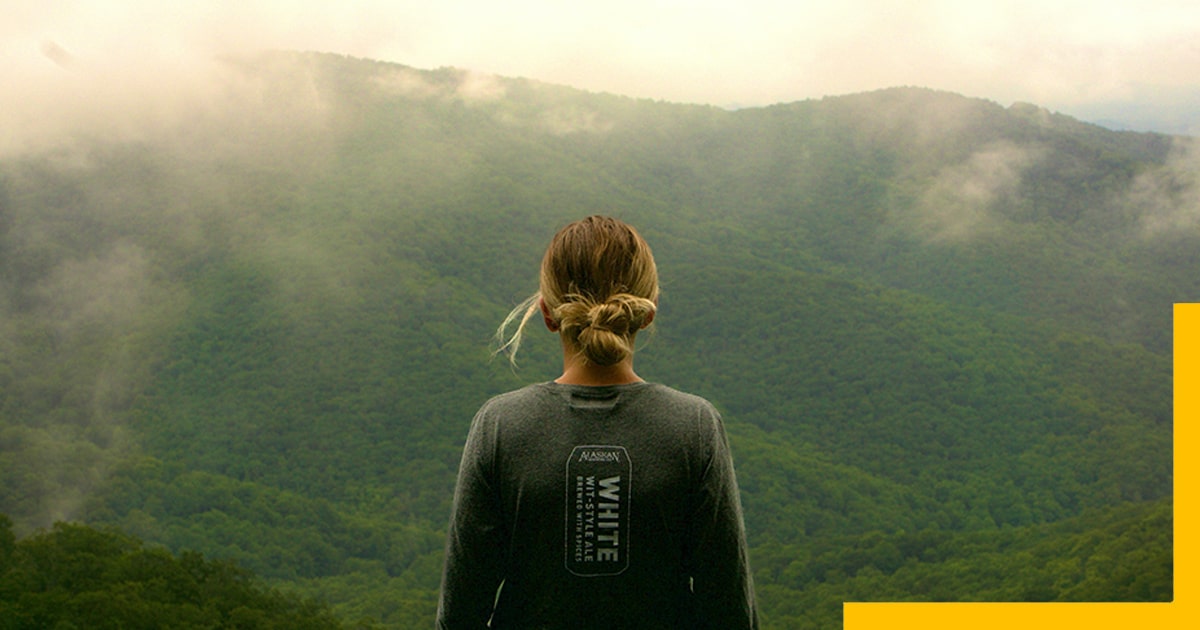 A girl enjoying the view of cloudy mountains