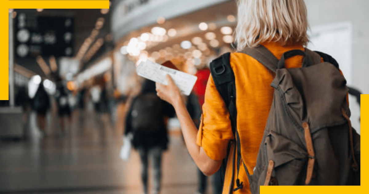 A woman on an airport holding tickets